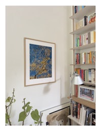 a living room with bookshelves and a framed painting